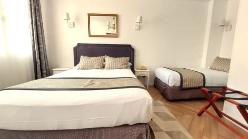 Chambre triple à l'Hôtel Dandy à Rouen avec deux lits aux têtes de lit violettes et oreillers rayés