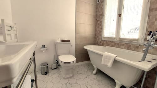 Salle de bain moderne de l'Hôtel Dandy à Rouen avec baignoire indépendante, toilettes, lavabo sur pied et carrelage