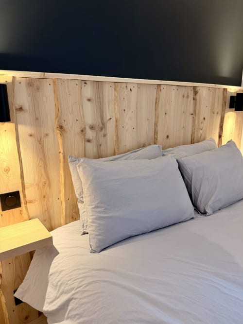 Lit double avec oreillers bleus et tête de lit en bois à l'Hôtel le Tilleul à Corps