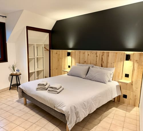 Chambre moderne à l'Hôtel le tilleul à Corps avec tête de lit en bois, literie blanche et mur d'accent foncé
