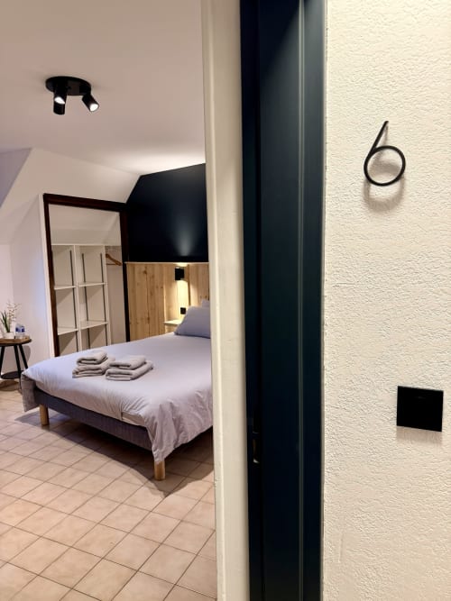 Chambre moderne à l'Hôtel le tilleul à Corps avec lit, miroir et équipements contemporains noirs