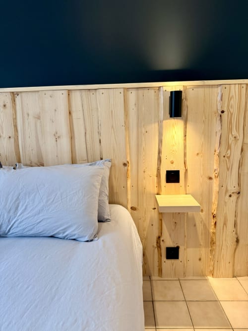 Chambre élégante aux lambris de bois clair avec literie blanche à l'Hôtel le tilleul à Corps, étagères intégrées et éclairage chaleureux