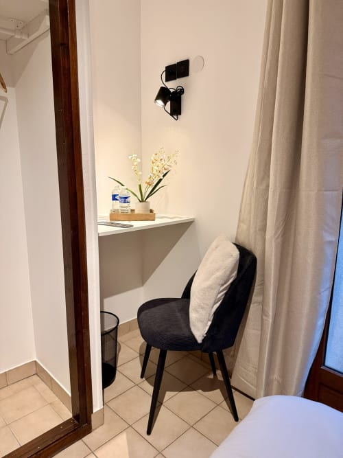 Chaise noire moderne à un bureau blanc avec fleurs dans la chambre de l'Hôtel le tilleul, Corps