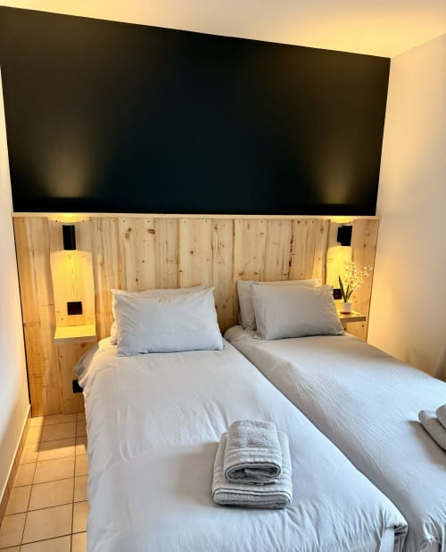 Chambre twin à l'Hôtel le tilleul à Corps avec tête de lit en bois, literie blanche et éclairage ambiant