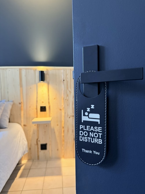 Panneau d'accroche-porte de l'Hôtel le Tilleul avec « Prière de ne pas déranger » sur la porte bleue d'une chambre, Corps, France