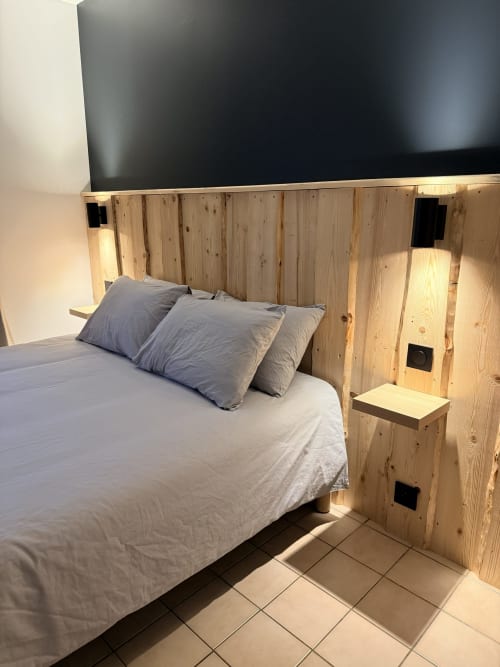 Lit en bois moderne avec oreillers gris à l'Hôtel le tilleul à Corps, France