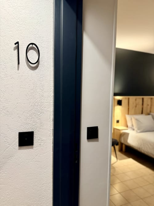 Entrée de la chambre 10 à l'Hôtel le tilleul à Corps, France avec murs blancs texturés et cadre sombre