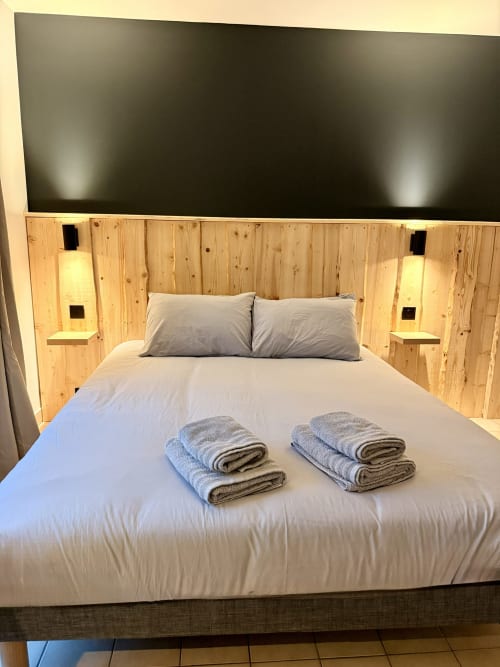 Grand lit avec serviettes pliées à l'Hôtel le tilleul à Corps, hôtel de montagne dans les Alpes françaises