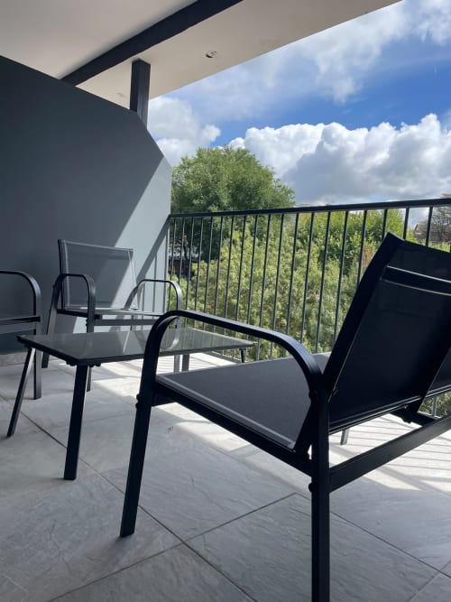 Moderno balcón con asientos en Hotel Arenas Rio en Arenas de San Pedro. Sillas negras con vistas al paisaje verde