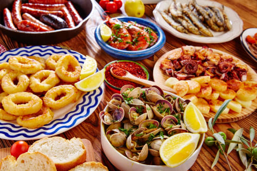 Tabla de mariscos españoles en Hotel Arenas Rio: calamares fritos, almejas, camarones y delicias locales con limón