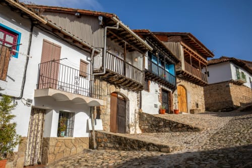 Edificios coloniales históricos con paredes blancas y balcones de madera en Arenas de San Pedro, Hotel Arenas Rio