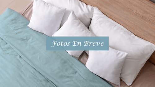 Cama confortable con almohadas blancas y ropa de cama azul claro en la casita The Boss de El Patrón Casa de Huéspedes, El Cotillo