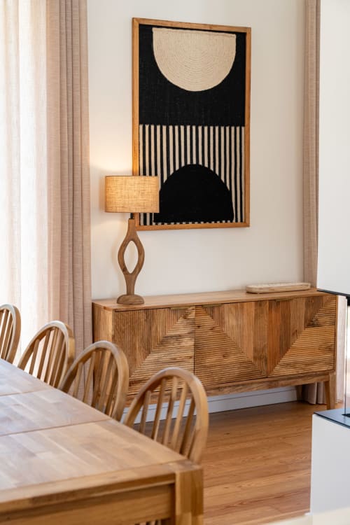 Mid-century modern dining room at Sea'Ya Villa Juso with wooden furniture, geometric wall art, and warm ambient lighting