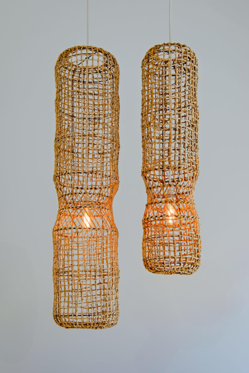 Two woven rattan pendant lights hanging against white wall at Sea'Ya Villas mountain villa