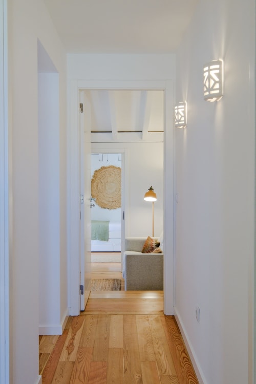 Bright hallway in Sea'Ya Villa Juso with wooden floors, white walls, and views into modern living spaces with natural décor.