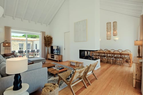 Modern villa living room with wooden floors, fireplace, dining area, and mountain views at Sea'Ya Villas in Aldeia de Juso,