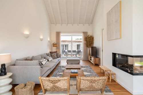 Modern living room in Sea'Ya Villa Juso with gray sofa, fireplace, and mountain views through glass doors