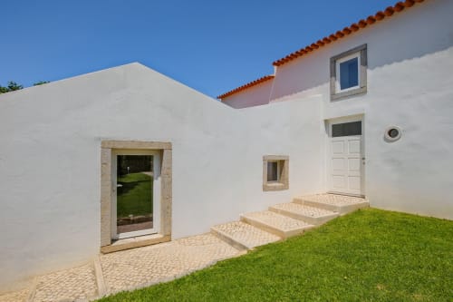 Modern white villa with terrace, manicured lawn, and stone steps at Sea'Ya Villas in Aldeia de Juso, Portugal