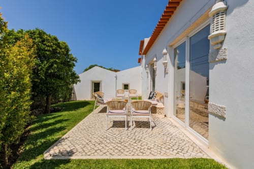 Sea'Ya Villa Juso's garden patio with wicker chairs, terrace seating, and mountain views in Aldeia de Juso, Portugal