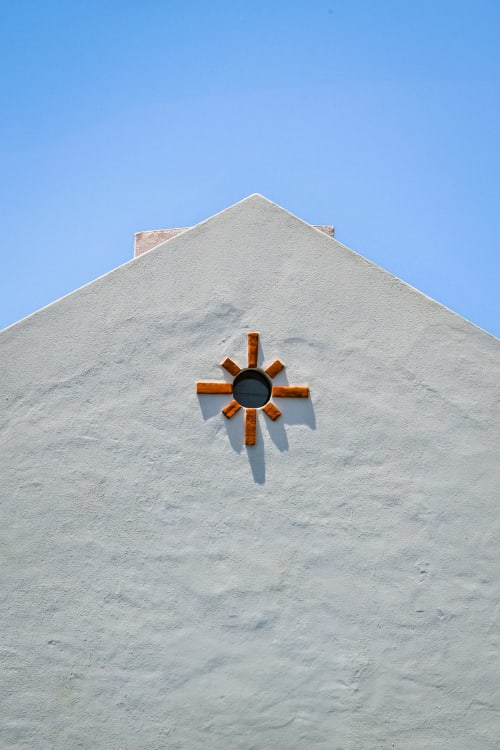 Whitewashed villa with terracotta star symbol and chimney against clear blue sky in Aldeia de Juso, Portugal