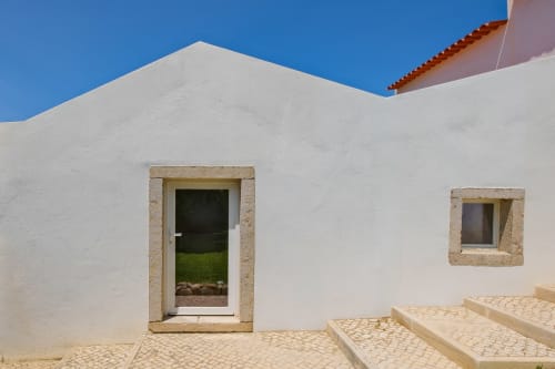 Whitewashed villa entrance with stone-framed door and window overlooking garden, Sea'Ya Villas in Aldeia de Juso, Portugal