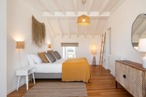 Bright modern villa bedroom with wooden floors, white beamed ceiling, and mountain view doors at Sea'Ya Villas