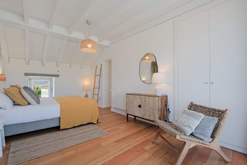 Bright bedroom at Sea'Ya Villa with wooden floors, white vaulted ceiling, yellow bedding, and modern furnishings overlooking