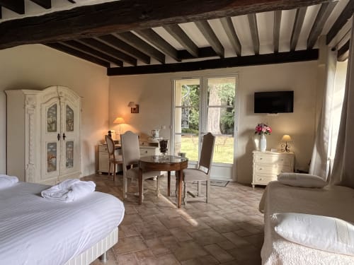Chambre Le Manoir au Colombier de Hanches avec lits jumeaux, portes sur jardin et plafond aux poutres apparentes
