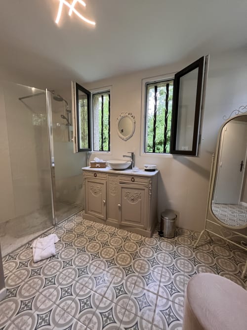 Salle de bain moderne au Colombier de Hanches avec vasque, douche, carreaux motifs et vue sur le jardin
