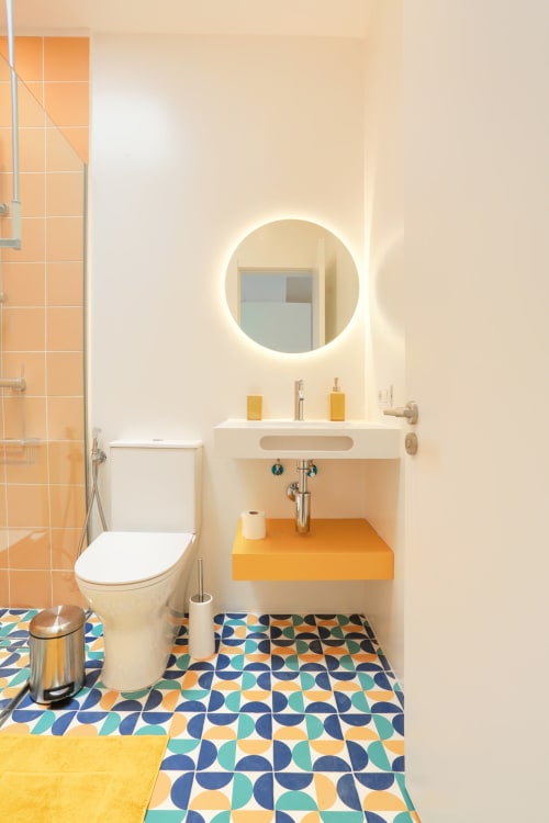 Baño moderno en El Patrón Casa de Huéspedes, El Cotillo, con azulejos geométricos coloridos y espejo redondo iluminado