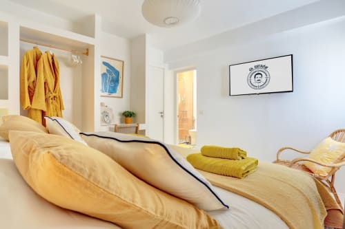 Acogedora habitación en El Patrón Casa de Huéspedes, El Cotillo, con ropa de cama amarilla, arte azul y comodidades modernas