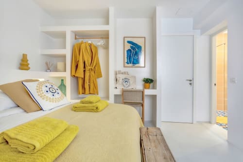 Dormitorio amarillo brillante en El Patrón Casa de Huéspedes en El Cotillo con estanterías modernas, arte azul costero y diseño minimalista