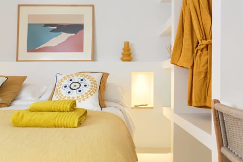 Dormitorio luminoso en El Patrón Casa de Huéspedes con ropa de cama amarilla, almohada decorativa y toques mostaza en El Cotillo