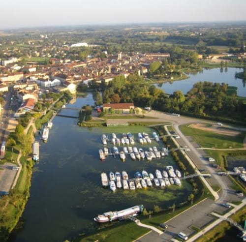 Vue aérienne du Jardin de la Reyssouze à Gorrevod avec bateaux amarrés, cadre fluvial et bâtiments de la ville