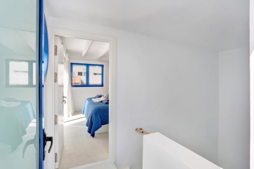 Pasillo con puerta azul que conduce al dormitorio en El Patrón Casa de Huéspedes, El Cotillo