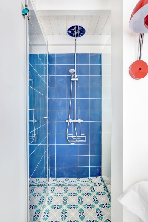 Ducha moderna con azulejos azules en El Patrón Casa de Huéspedes, El Cotillo con alcachofa de lluvia cenital y diseño geométrico