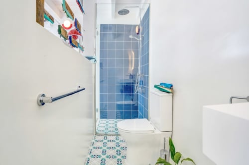 Baño moderno en El Patrón Casa de Huéspedes en El Cotillo con ducha de azulejos azules y piso de baldosas geométricas