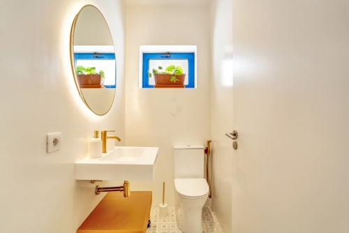Cuarto de baño moderno en Habitación Jarea del El Patrón Casa de Huéspedes, El Cotillo, con espejo ovalado, lavamanos blanco, inodoro y