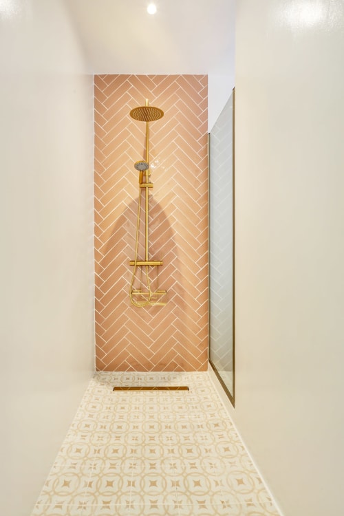 Ducha moderna en Habitación Jarea de El Patrón Casa de Huéspedes, El Cotillo. Herrajes dorados con azulejos en espiga.