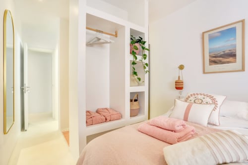 Habitación luminosa en El Patrón Casa de Huéspedes, El Cotillo, con ropa de cama rosa, armario empotrado y decoración costera