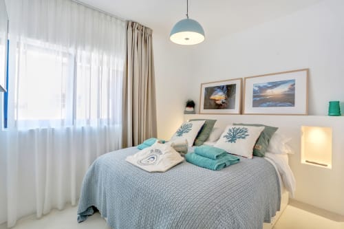 Luminosa habitación en El Patrón Casa de Huéspedes, El Cotillo, con lámpara colgante azul, cuadro del océano y turquesa