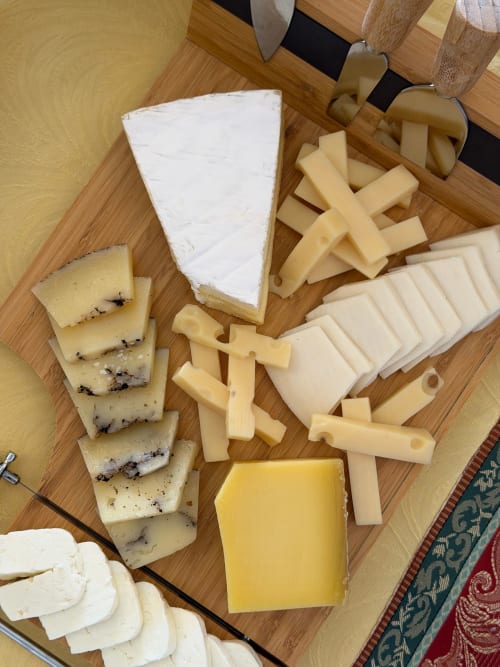 Selezione di formaggi assortiti su tavola di legno al Resort Baia Cea, Bari Sardo