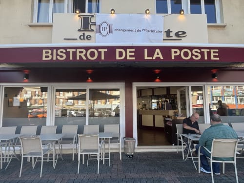 Façade du Bistrot de la Poste à Saint-Valery-en-Caux, devanture bourgogne, chaises blanches et terrasse