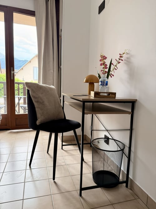 Espace de travail moderne à l'Hôtel le tilleul à Corps avec vue sur les montagnes, chaise noire et lampe en laiton