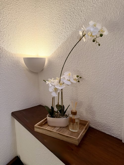 Coin élégant d'une chambre d'hôtel avec orchidée blanche, plateau en bois et applique murale à l'Hôtel le Tilleul à Corps, France