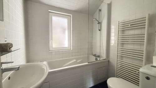 Modern bathroom at Le Gite De Saint Phal B&B with bathtub, walk-in shower, toilet, heated towel rack and window