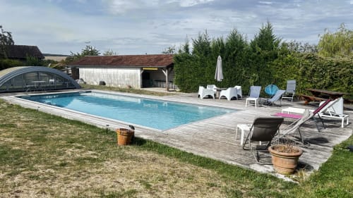 Le Gite De Saint Phal outdoor swimming pool with lounge chairs and wooden deck in France