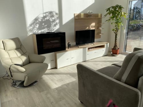 Séjour moderne du gîte Les vallées de l'Artois avec canapé confortable, écran plat et cheminée