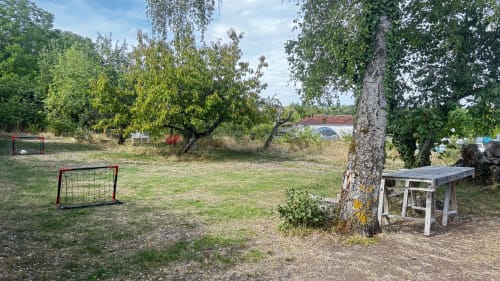 Rustic outdoor garden area at Le Gite De Saint Phal in Saint-Phal, France, with soccer goal and bench under trees