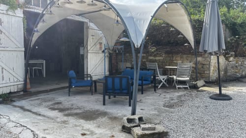 Outdoor patio area at Le Gite De Saint Phal B&B in Saint-Phal with blue seating, shade structures, and garden furniture